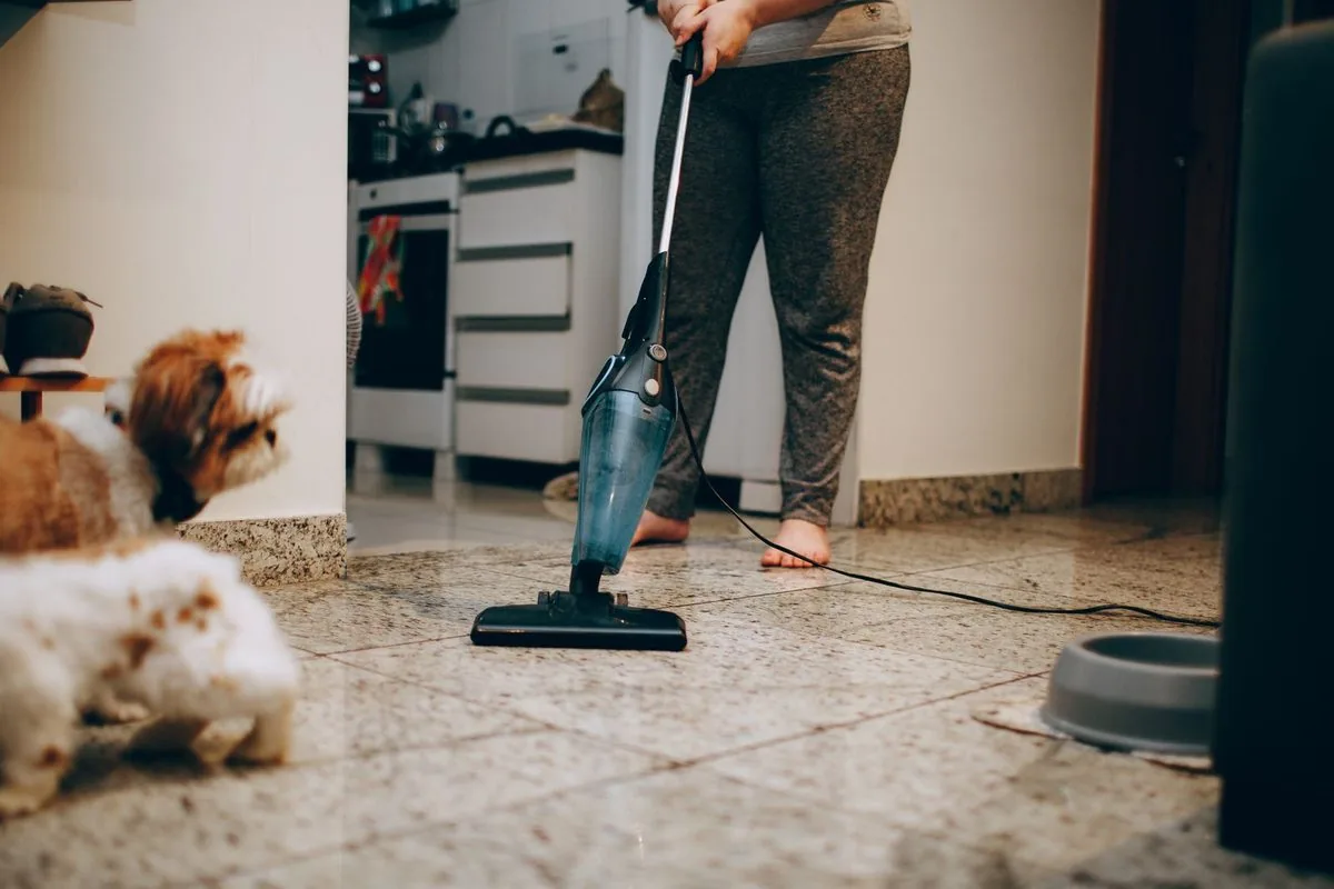 Cleaner vacuuming the floor of a lived-in living room